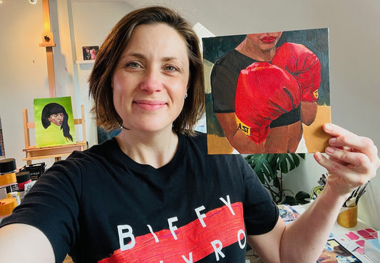 Louise holding painting of woman boxing