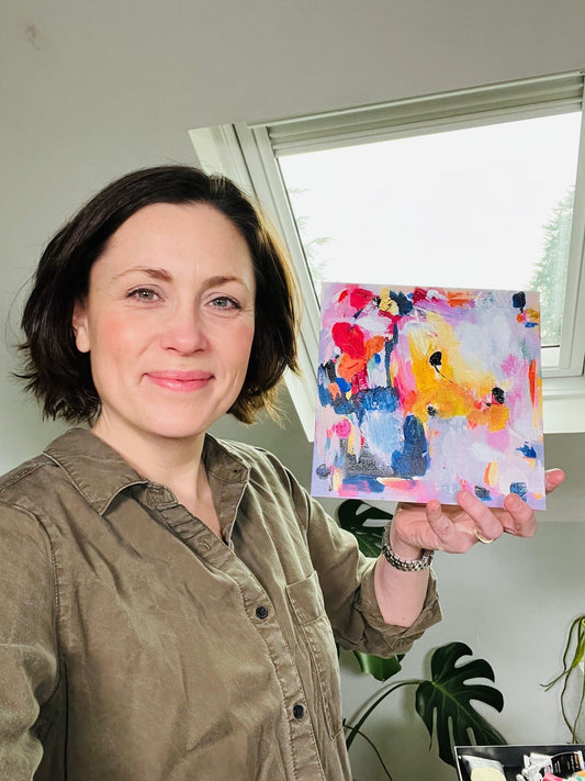 Louise holding painting in studio